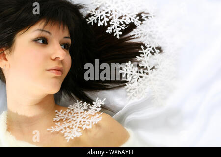 Fille de noël jette sur blanc flocons de neige tombent sur une tête Banque D'Images