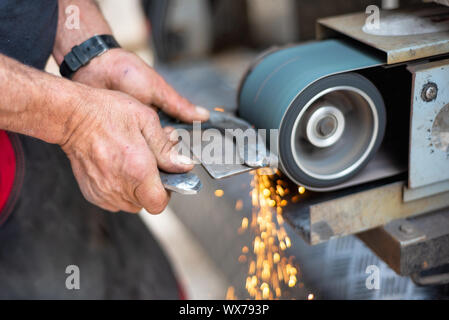 L'industrie du métal. Surface métallique de finition sur machine de meulage. Banque D'Images