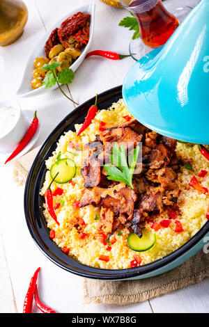 Tajin avec du couscous, légumes et viande sur fond blanc Banque D'Images