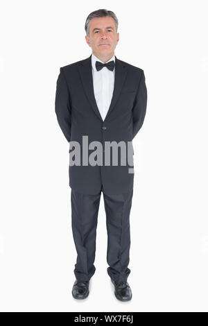 Man in suit debout avec les mains derrière le dos Banque D'Images