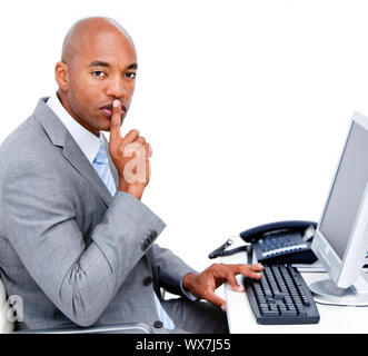 Confident businessman pour demander le silence assis à son bureau dans le bureau Banque D'Images