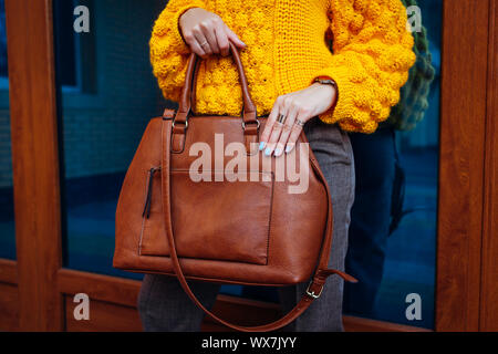 Sac à main. Woman holding sac élégant et porter le chandail jaune. Femme automne Vêtements et accessoires. Fashion Banque D'Images