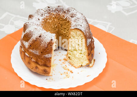 L'anneau fait maison cake saupoudrés de sucre glace on white plate Banque D'Images