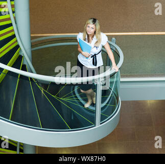 En montant un escalier blond businesswoman in office Banque D'Images