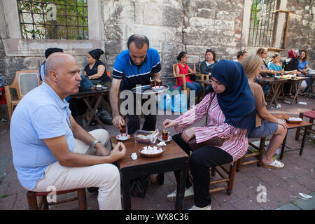 Waiter serving plateau aux clients à une maison de thé (cay evi) dans le district de Fatih Istanbul Banque D'Images