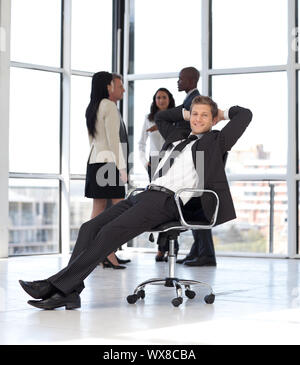 Dans Businesssman les jeunes assis sur une chaise de bureau Banque D'Images