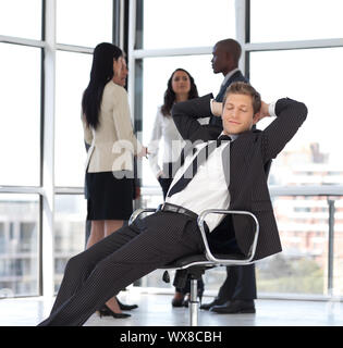 Dans Businesssman les jeunes assis sur une chaise de bureau Banque D'Images