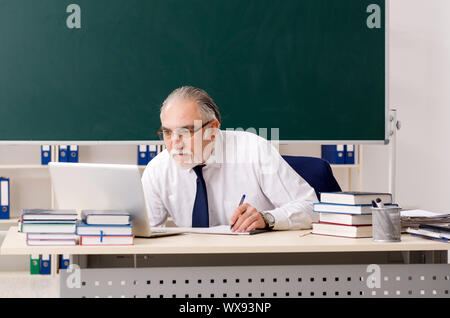 Enseignant de sexe masculin âgés de à l'avant du tableau Banque D'Images