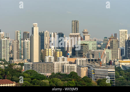 Singapour - Mars 21, 2019 : tourné sur des centaines de gratte-ciel sous ciel chaude et brumeuse. Centré sur l'hôtel Mandarin Orchard. Feuillage vert de Fort Canning n Banque D'Images