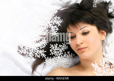 Fille de noël jette sur blanc flocons de neige tombent sur une tête Banque D'Images