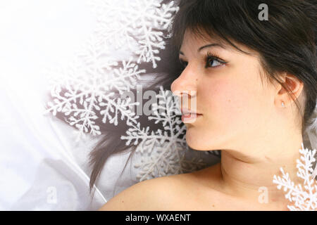 Fille de noël jette sur blanc flocons de neige tombent sur une tête Banque D'Images