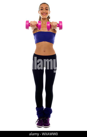Grande et mince woman holding dumbbells rose dans ses bras tendus. Banque D'Images