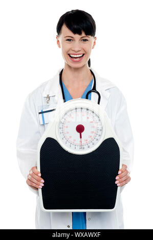 Médecin chef enthousiaste afficher une balance. Banque D'Images