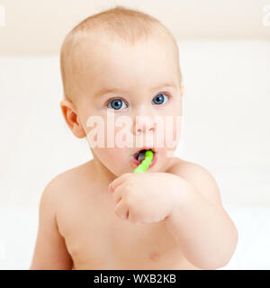 Little baby girl avec brosse à dents verte Banque D'Images