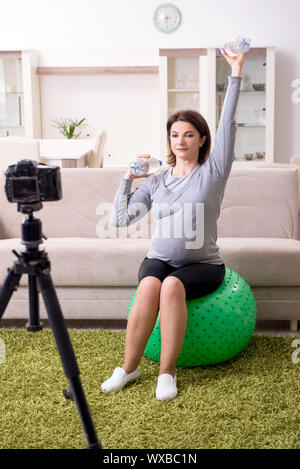 Femme enceinte blogger faisant des exercices physiques Banque D'Images