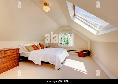 Grenier chambre à coucher moderne avec lit blanc et du puits et des murs beiges et tapis. Banque D'Images