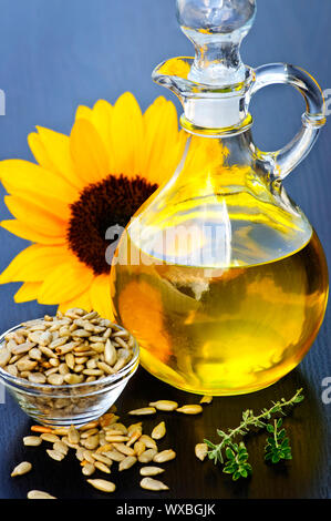 Bouteille d'huile de tournesol avec les graines et fleurs Banque D'Images