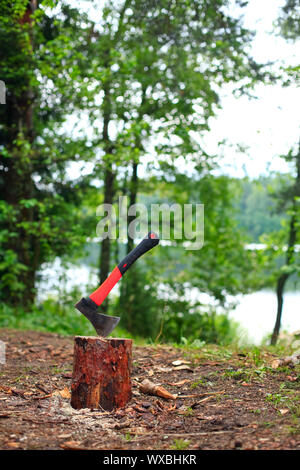 Camping ax coincé dans un morceau de bois Banque D'Images