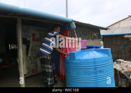 Une Femme Recueille De L Eau De Pluie En Utilisant Une Feuille De Plastique Sous Le Toit En