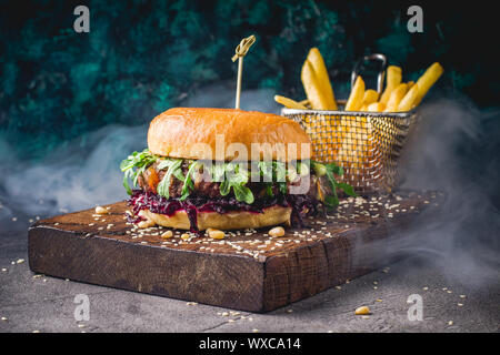 Les hamburgers et les frites sur le plateau en bois Banque D'Images
