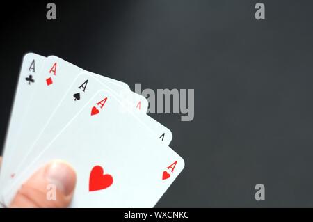 Main tenant quatre As avec bokeh copyspace Banque D'Images