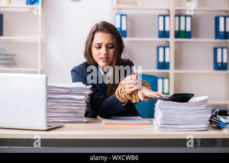 Belle jeune employé attaché avec une corde dans le bureau Banque D'Images