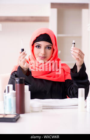 Belle femme en hijab applying make-up Banque D'Images