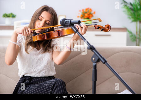 Belle femelle musicien à jouer du violon à la maison Banque D'Images