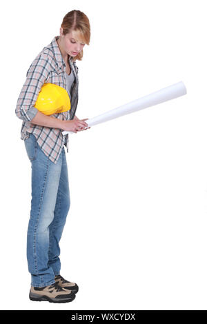 Belle blonde carpenter holding blueprints isolated on white Banque D'Images