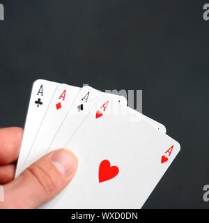 Main tenant quatre As avec bokeh copyspace Banque D'Images