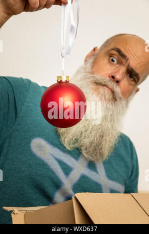 Homme barbu à la boule de noël rouge à Banque D'Images