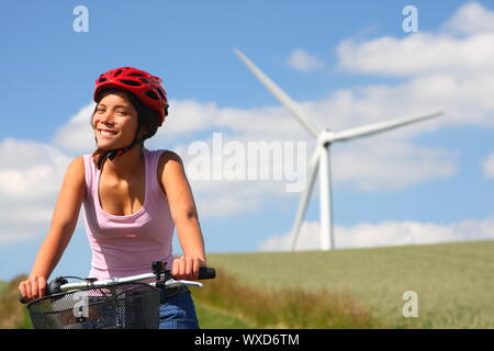 Femme se détendre et profiter du soleil sur une excursion à bicyclette dans la campagne de Jutland, Danemark Wind turbine à l'arrière-plan. Banque D'Images