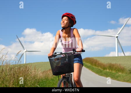 Femme se détendre et profiter du soleil sur une excursion à bicyclette dans la campagne de Jutland, Danemark Moulin en arrière-plan. Banque D'Images