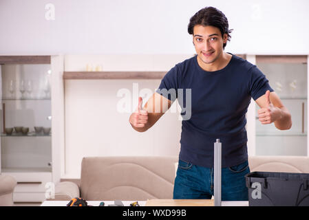 Jeune homme la réparation de meubles à la maison Banque D'Images