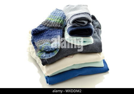 Une pile de vêtements de bébé avec chaussettes isolé sur un fond blanc. Banque D'Images