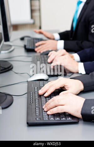La main sur l'homme pour taper sur le clavier et souris de défilement Banque D'Images
