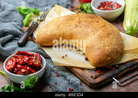 Des pizzas calzone sur une planche de bois. Banque D'Images