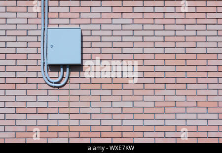 Compteur électrique fermé sur le mur de brique d'une maison