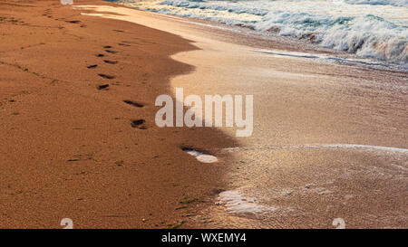 Les traces de pas dans le sable par la mer Banque D'Images