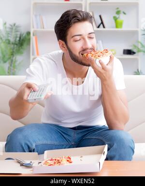 Man eating pizza à emporter à la maison avoir un repos relaxant Banque D'Images