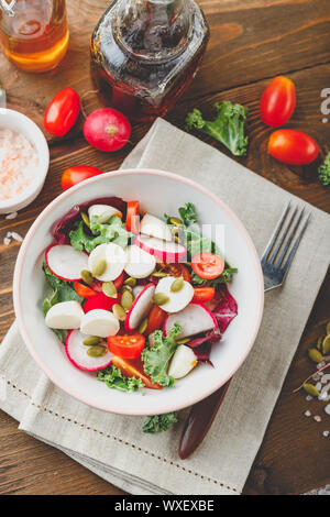 Salade avec tomates cerises, mozzarella et radsh, mélange de laitue Banque D'Images