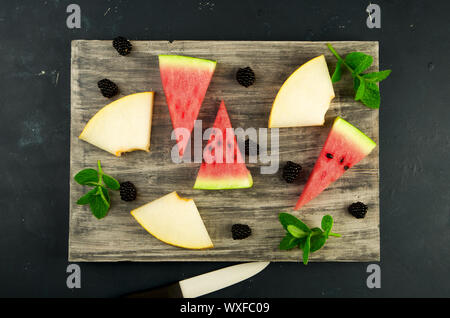 La pastèque MELON ET MENTHE BLACKBERRY SUR L'ARRIÈRE-PLAN. Trois MORCEAUX DE PASTÈQUE MELON mûr juteux avec des Mûres Mûres MINT Banque D'Images