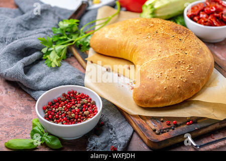 Des pizzas calzone sur une planche de bois. Banque D'Images