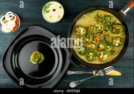 La courgette dans l'arrière-plan. Les jeunes courgettes en rondelles frites dans une casserole sur un fond sombre. La vue du sommet. Copy space Banque D'Images