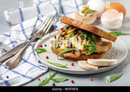 Petit-déjeuner avec des œufs brouillés et des champignons sur toast. Banque D'Images