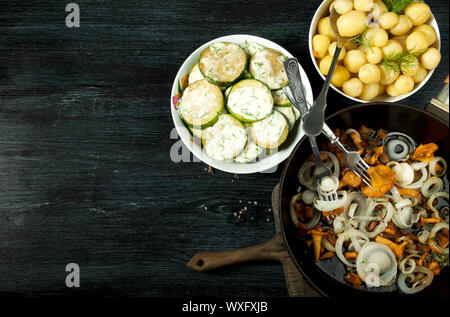 Des légumes sur l'arrière-plan. Sauce de courgettes frites dans une assiette. Les jeunes pommes de terre bouillies avec de l'aneth dans un bol. Chanterelles poêlées bouillie Banque D'Images