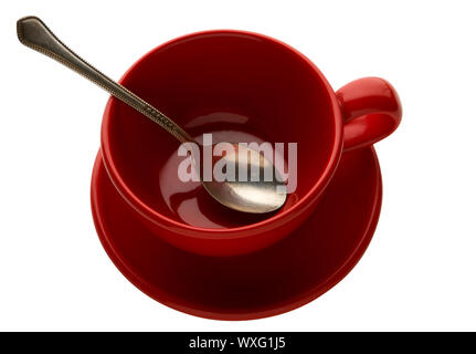 Cuillère dans une tasse sur une plaque sur l'isoler. L'argile vide mug avec cuillère sur un plat sur une surface isolée. Banque D'Images