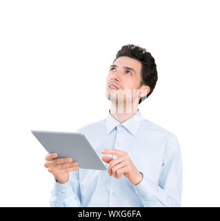 Portrait of a young handsome businessman holding tablet computer et à la recherche. Isolé sur fond blanc Banque D'Images