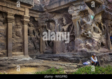 Ellora, Maharashtra, Inde - 15 janvier 2018 : les grottes d'Ellora. Un homme se repose près des murs d'un ancien temple Banque D'Images