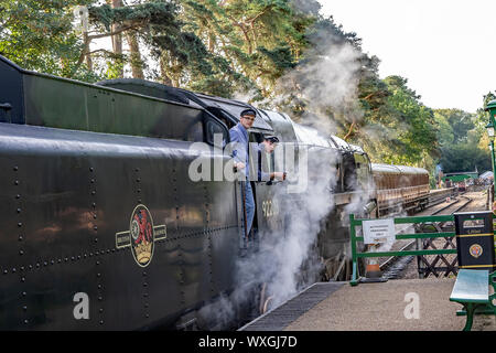 Conducteur de train et s'accouplent à la Chambre entre le Prince Noir train à vapeur Holt railway station Banque D'Images
